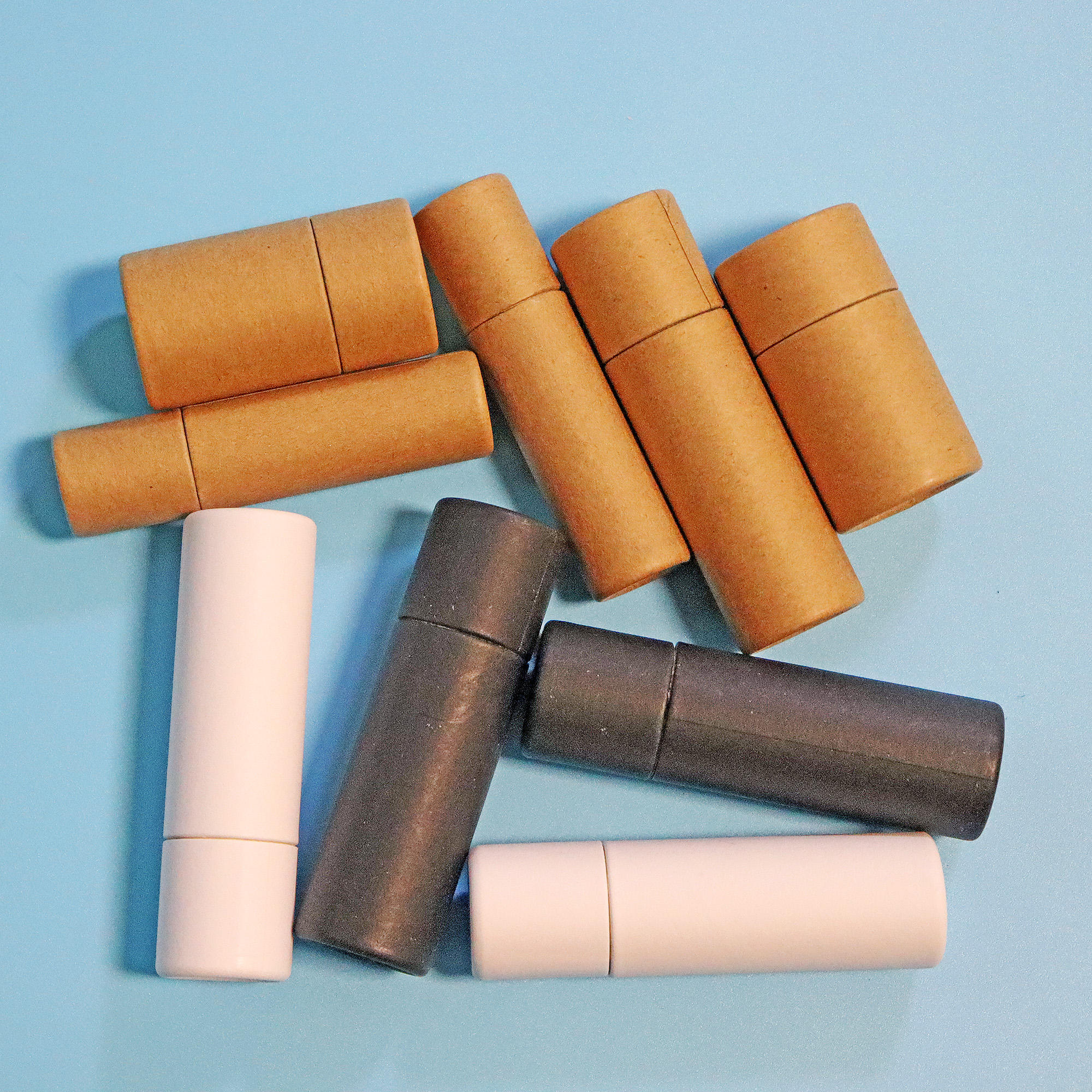 Коричневый тюбик из крафт-бумаги. Бумажный упаковочный тюбик. Белый биоразлагаемый дезодорирующий блеск для губ. Бумажный тюбик с эффектом пуш-ап для упаковки бальзама для губ.